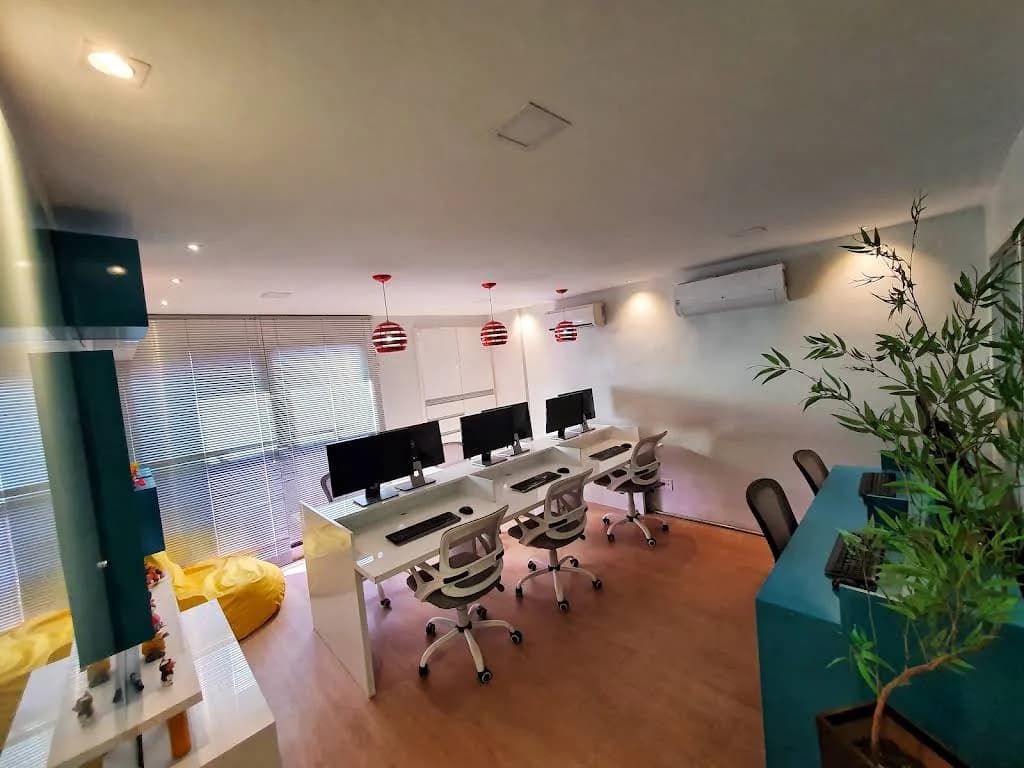 Área de trabalho do escritório da Mix7 com mesas, monitores e cadeiras