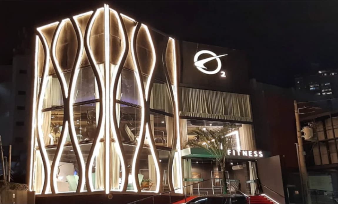 Fachada iluminada de uma unidade da O2 Fitness