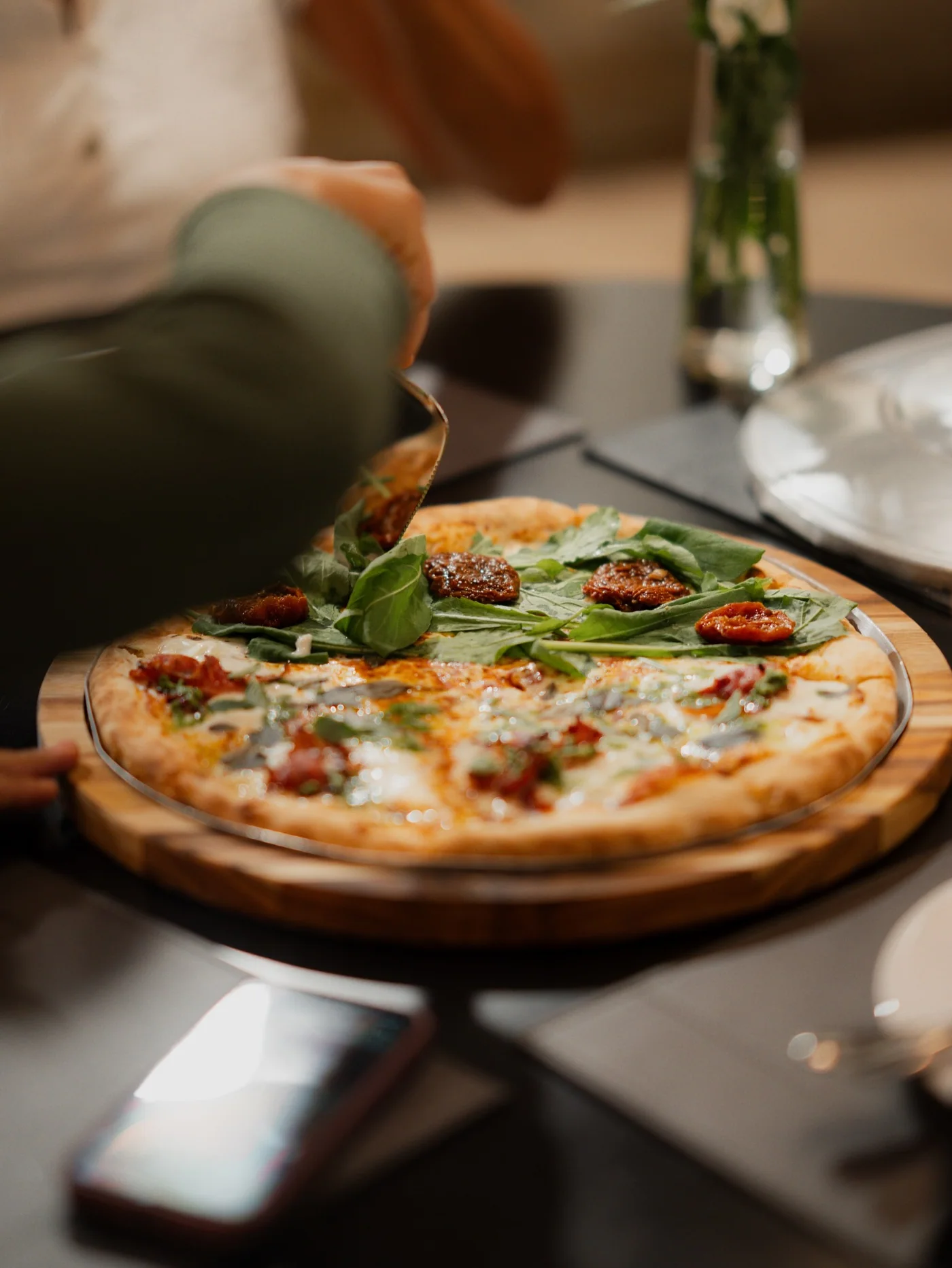 Pizza da Nostra Italia recebendo a finalização antes de ser servida